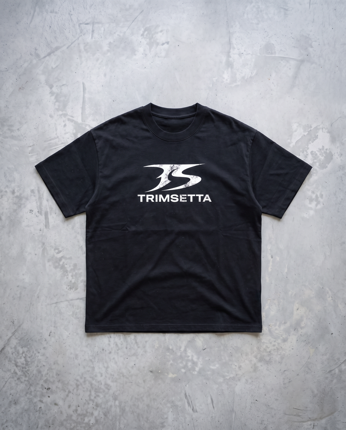 Blackout Tee – flat lay on concrete
