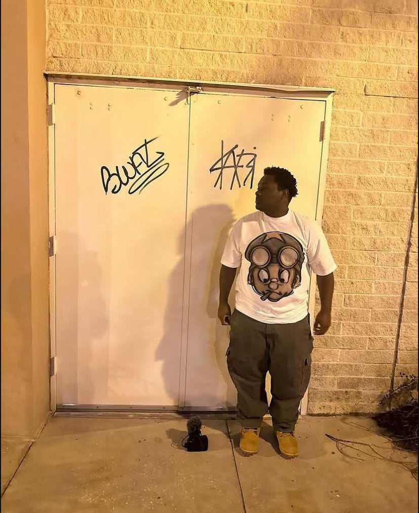 Customer in the Vertidíem Fight for Freedom tee standing by white doors at night