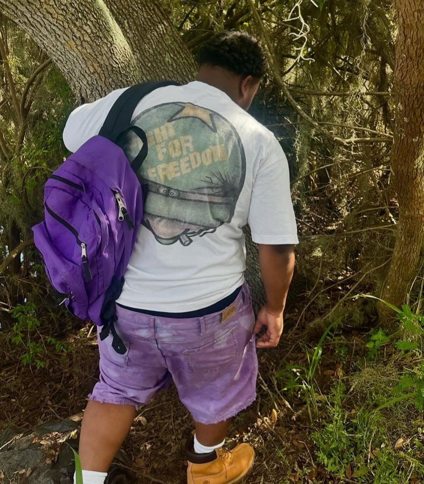 Back print of the Vertidíem Fight for Freedom tee worn outdoors with a backpack